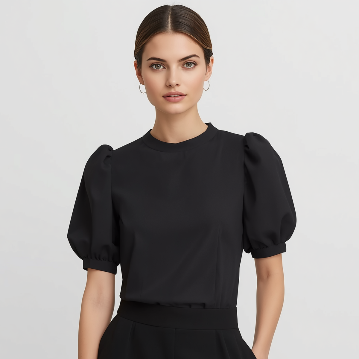 Blusa de mujer en color negro con cuello redondo y mangas largas de corte abullonado.