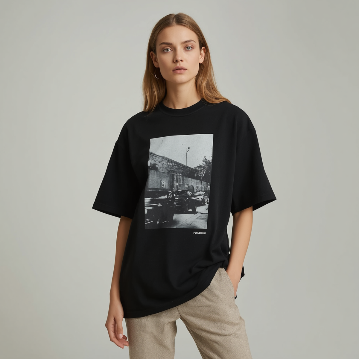 Camiseta oversize de mujer en color negro con cuello redondo, manga corta y estampado gráfico cuadrado en blanco y negro en la parte delantera.