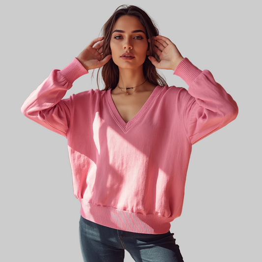 Jersey de mujer en color rosa con escote en V, mangas largas y remates elásticos en los puños y el dobladillo.